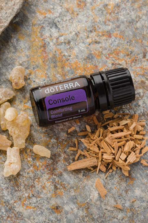 Флакон смеси Console dōTERRA рядом с ладаном и сандалом