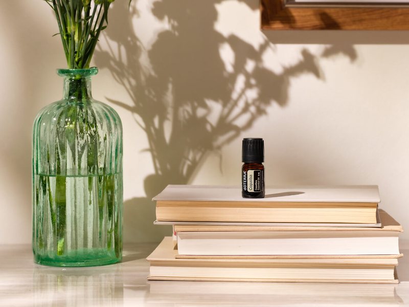 Флакон dōTERRA на стопке книг