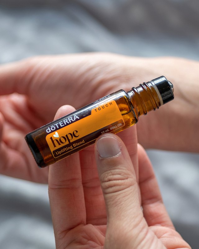 Роллер со смесью dōTERRA Hope Touch в руках