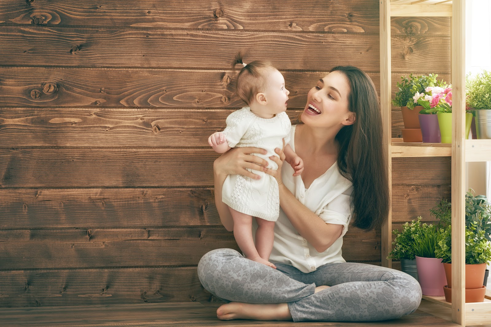 Статус Директор в dōTERRA: условия и что даёт Статус Директор в dōTERRA: условия и что даёт: мама подбрасывает малыша у деревянной стены