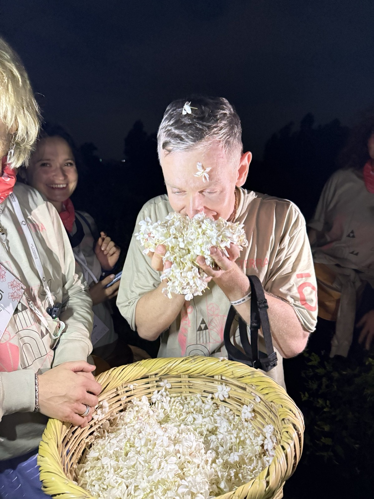 Участница саммита с корзиной свежего жасмина, счастливая, в цветах